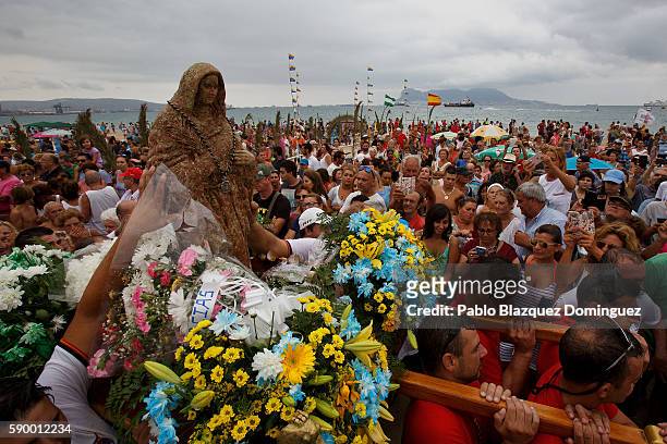 Divers and fishermen carry the image of the Virgin of Palm as worshippers gather around at El Rinconcillo beach during the yearly Virgin of Palm...