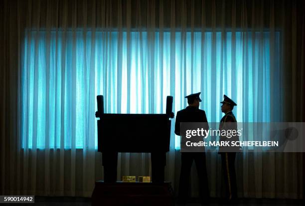 China's People's Liberation Army officers stand in front of a window before a welcome ceremony for US Army Chief of Staff General Mark Milley at the...