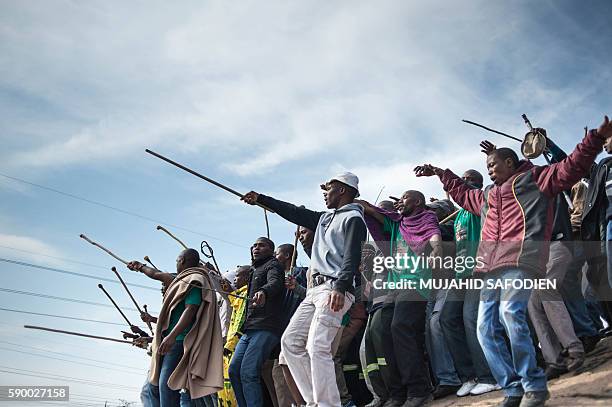 Miners dance during commemorations to mark the fourth anniversary of the Marikana Massacre in Rustenburg on August 16, 2016. On August 16 workers at...