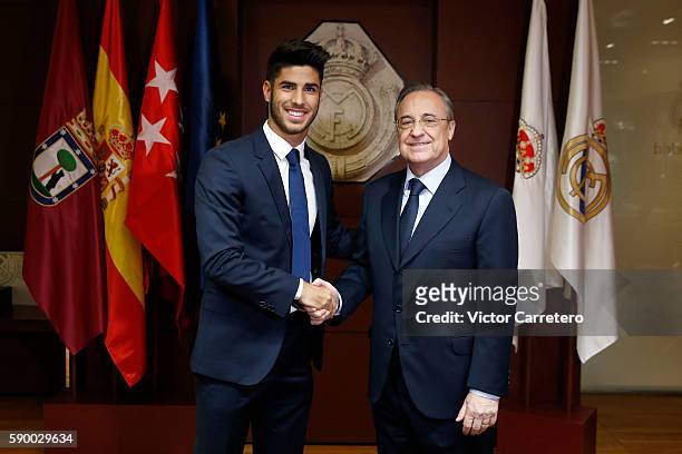Marco Asensio of Real Madrid shakes hands with Real Madrid president Florentino Perez during his official presentation at Estadio Santiago Bernabeu...