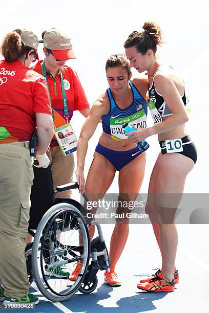 Abbey D'Agostino of the United States is helped by Nikki Hamblin of New Zealand after the Women's 5000m Round 1 - Heat 2 on Day 11 of the Rio 2016...