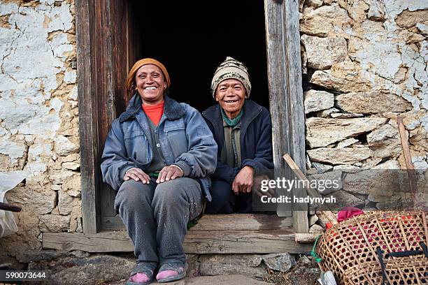 nepali couple in front of their house - tibet stock pictures, royalty-free photos & images