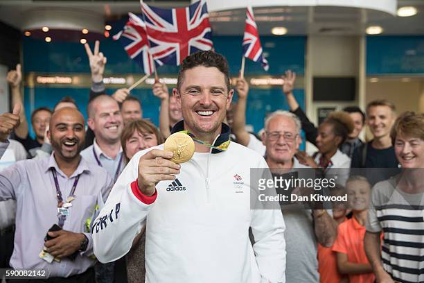 Golfer Justin Rose of Great Britain poses with his Gold Medal after arriving on a British Airways flight from Rio de Janeiro in Brazil to London...