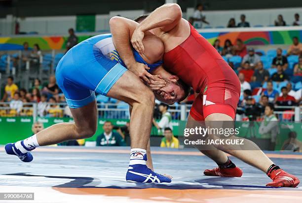 Hungary's Balazs Kiss wrestles with Ukraine's Dimitriy Timchenko in their men's 98kg greco-roman qualification match on August 16 during the...