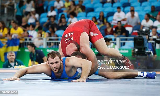 Hungary's Balazs Kiss wrestles with Ukraine's Dimitriy Timchenko in their men's 98kg greco-roman qualification match on August 16 during the...