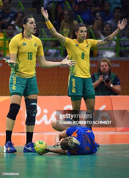 Netherlands' centre back Nycke Groot lies on the ground after being fouled past Brazil's right wing Eduarda Amorim and Brazil's left wing Fernanda...