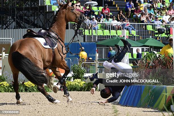 Australia's Scott Keach riding Fedor falls during the Equestrian Jumping Inividual qualifications at the Olympic Equestrian Center during the Rio...