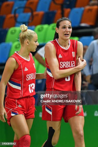 Serbia's forward Sonja Petrovic holds her arm, escorted by Serbia's point guard Milica Dabovic , after falling during a Women's quarterfinal...