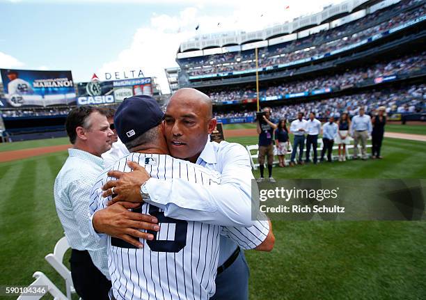 Manager Joe Girardi and Mariano Rivera hug after a monument plaque ceremony honoring Rivera before a game between the Tampa Bay Rays and the New York...