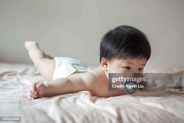 baby boy flying on bed - gymnastic asian stockfoto's en -beelden