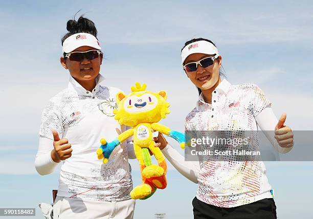 Michelle Koh and Kelly Tan of Malaysia pose together during a practice round prior to the start of the women's golf during Day 11 of the Rio 2016...