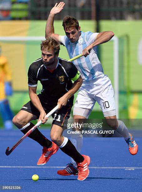Germany's Moritz Furste vies with Argentina's Matias Paredes during the men's quarterfinal field hockey Argentina vs Germany match of the Rio 2016...