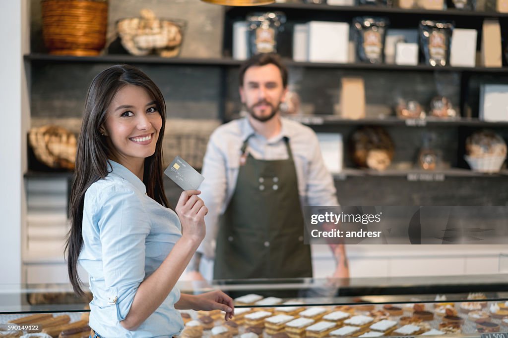 Woman paying by credit card at the bakery