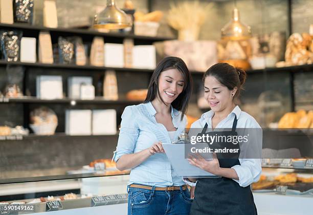 business owner talking to worker at a bakery - bakery apron bildbanksfoton och bilder