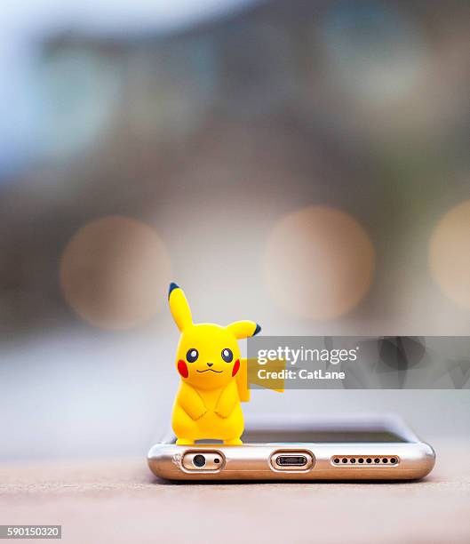 nintendo pokemon go character pikachu and iphone - pikachu stock pictures, royalty-free photos & images