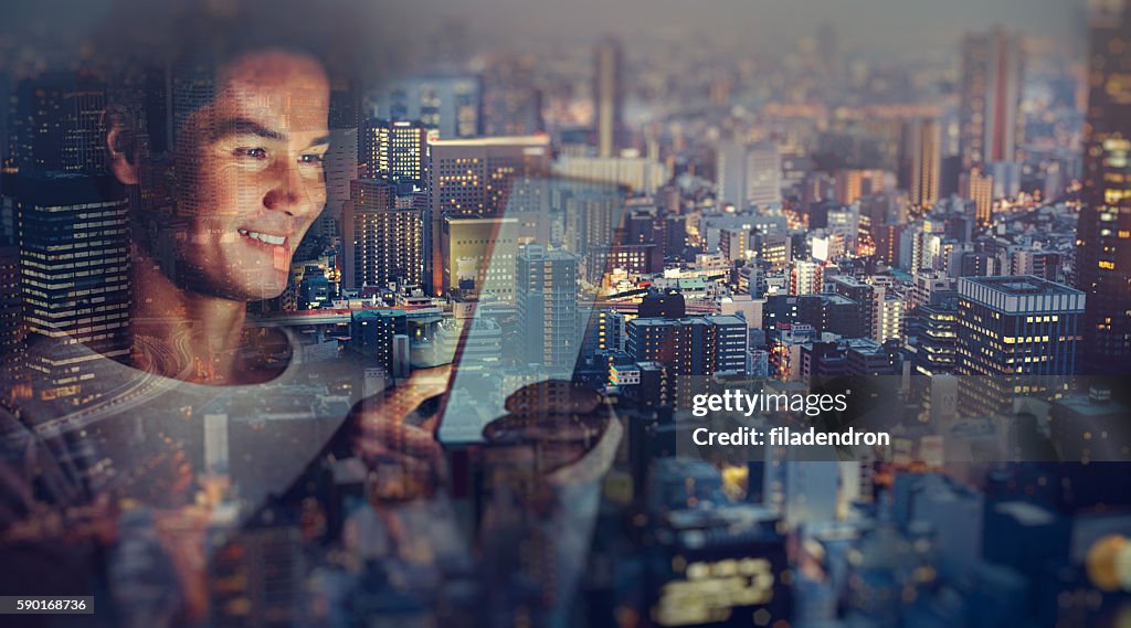 Young japanese man texting on the tablet