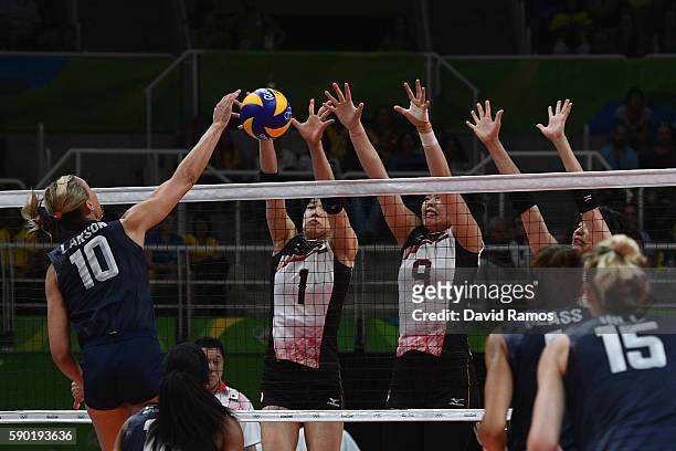 Jordan Larson-Burbach of The United States opikes the ball past Miyu Nagaoka and Haruyo Shimamura of Japan during the Women's Quarterfinal match...