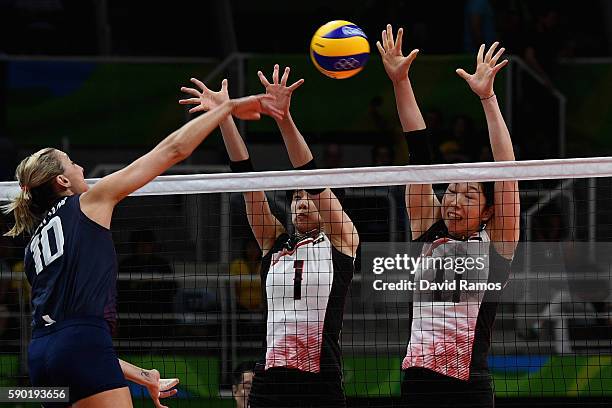 Jordan Larson-Burbach of The United States opikes the ball past Miyu Nagaoka and Erika Araki of Japan during the Women's Quarterfinal match between...