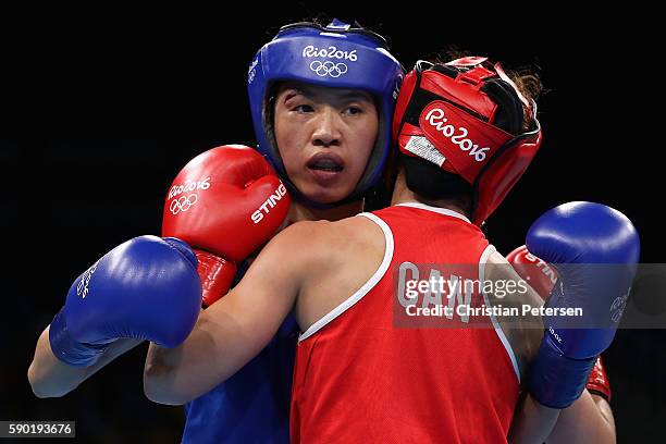 Cancan Ren of China is tied up with Mandy Bujold of Canada in the boxing Women's Fly Quarterfinal 2 on Day 11 of the Rio 2016 Olympic Games at...