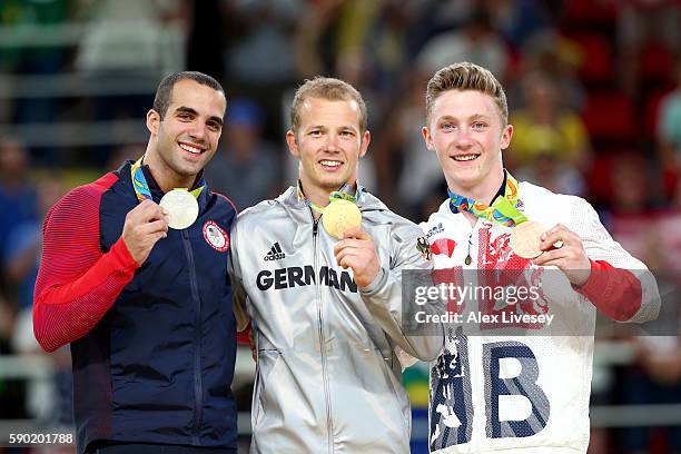 Silver medalist Danell Leyva of the United States, gold medalist Fabian Hambuechen of Germany and bronze medalist Nile Wilson of Great Britain pose...