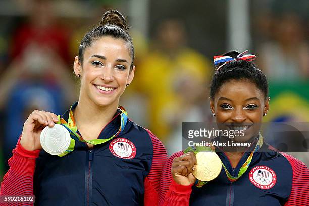 Silver medalist Alexandra Raisman and gold medalist Simone Biles of the United States pose for photographs on the podium at the medal ceremony for...