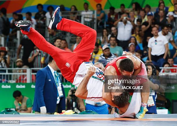 Serbia's Davor Stefanek celebrates with his coach after winning against Armenia's Migran Arutyunyan in their men's 66kg greco-roman final match on...