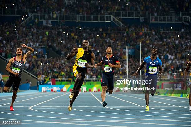 Summer Olympics: Jamaica Usain Bolt and USA Justin Gatlin crossing finish line and looking up to video screen during Men's 100M Final at the Olympic...