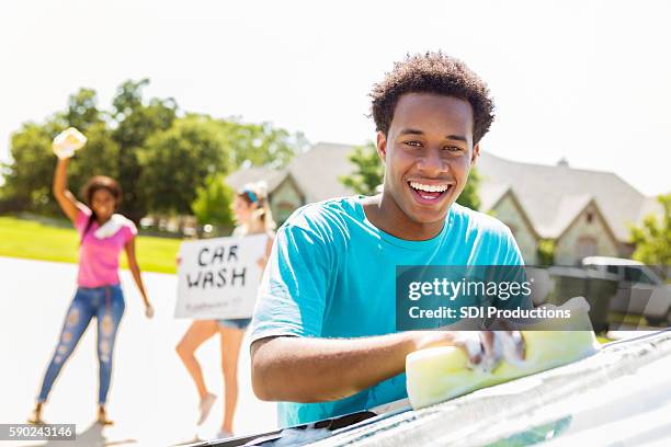 handsome african american teenage boy washing a car - teen wash car stock pictures, royalty-free photos & images