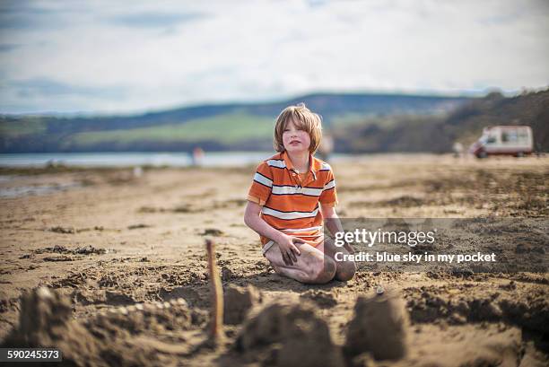 a young boy playing in the sand - city of spades bildbanksfoton och bilder