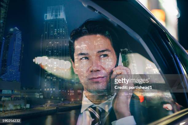 asiatischer geschäftsmann, der nachts mit dem auto unterwegs ist und telefoniert - management car smartphone stock-fotos und bilder