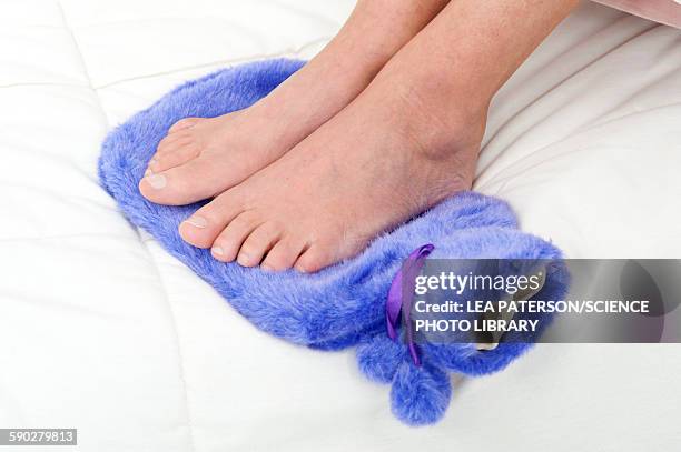 woman with feet on hot water bottle - hairy women imagens e fotografias de stock