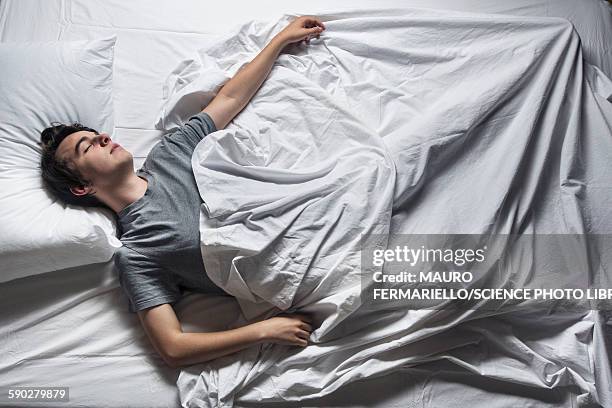man asleep in a bed - men in bed stock-fotos und bilder