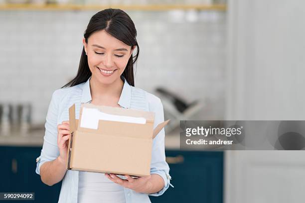 mujer recibiendo un paquete en el correo - receiving fotografías e imágenes de stock