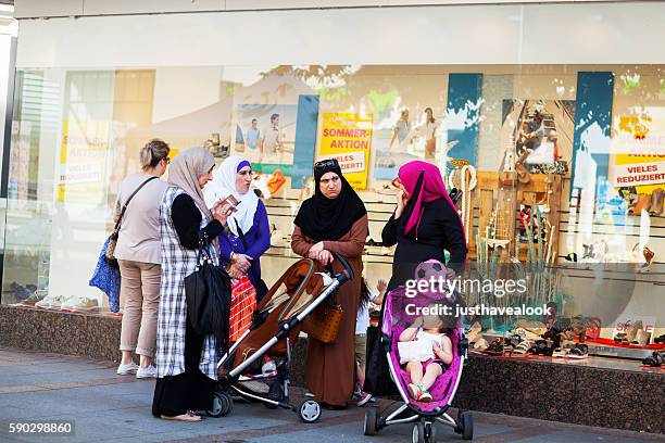 muslim women with baby buggies and children - burkini stock pictures, royalty-free photos & images