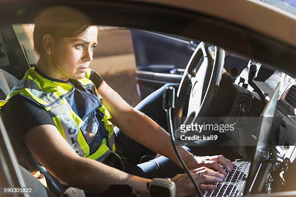 polizistin sitzbereich in patrouille auto computer benutzen - police sitting stock-fotos und bilder