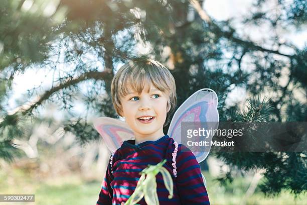 happy boy in fairy wings looking away at yard - princess stock pictures, royalty-free photos & images