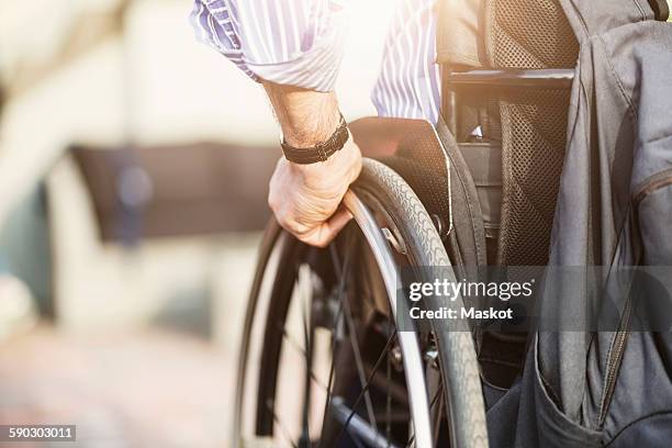cropped image of man in wheelchair outdoors - rolstoel stockfoto's en -beelden