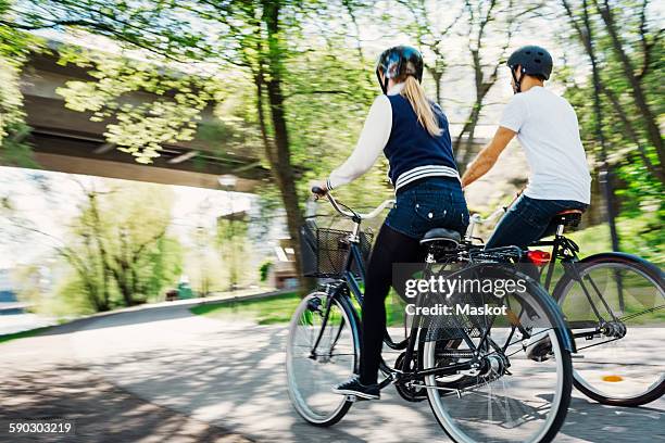 rear view of business people riding bicycles on street - stockholm park stock pictures, royalty-free photos & images