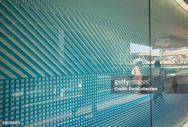 reflection of commuters in patterned glass facade - frau business glas modern stock-fotos und bilder