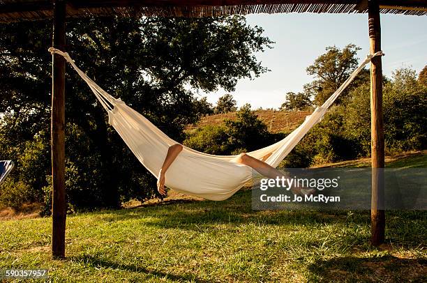 boy in a hammock, arm and leg sticking out - hamaca fotografías e imágenes de stock