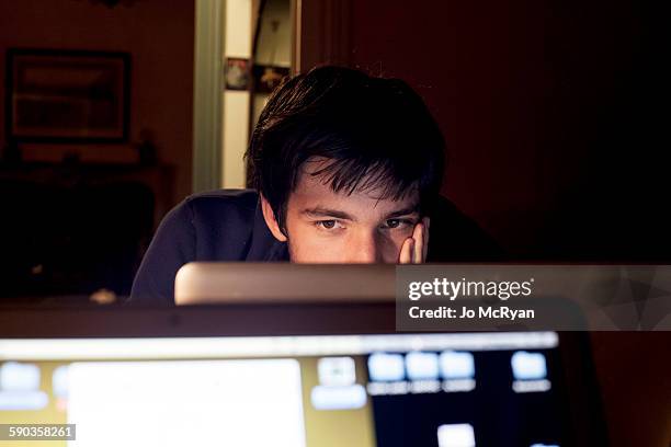 adolescent staring at computer screen - teen computer stock-fotos und bilder