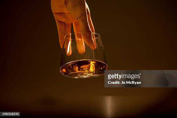hand holding glass - whiskey stock pictures, royalty-free photos & images