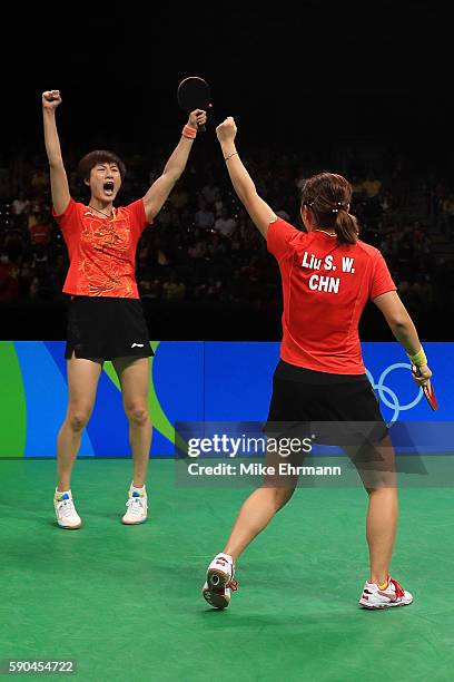 Ning Ding and Shiwen Liu of China celebrate winning gold in the their doubles match against Petrissa Solja and Xiaona Shan of Germany in the Women's...