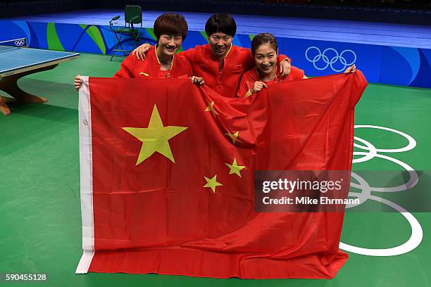 Xiaoxia Li, Shiwen Liu and Ning Ding of China celebrate winning gold in the Women's Team Gold Medal Team Match between China and Germany on Day 11 of...