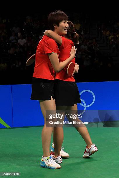 Ning Ding and Shiwen Liu of China celebrate winning gold in the their doubles match against Petrissa Solja and Xiaona Shan of Germany in the Women's...