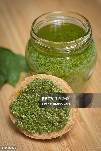 jar of homemade basil pesto and slice of bread - lifeispixels photos et images de collection