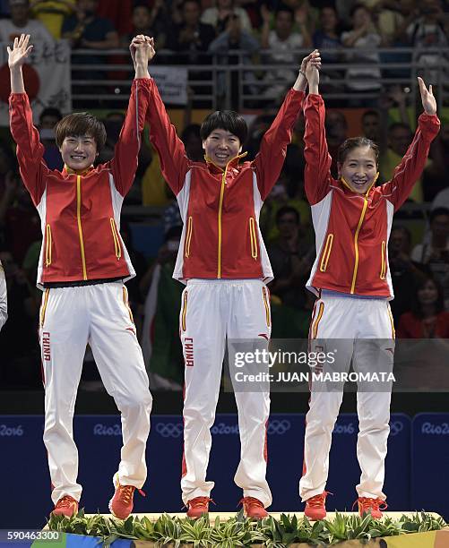 China's Ding Ning , China's Li Xiaoxia and China's Liu Shiwen celebrate as they recieve their gold medals after the women's team final table tennis...