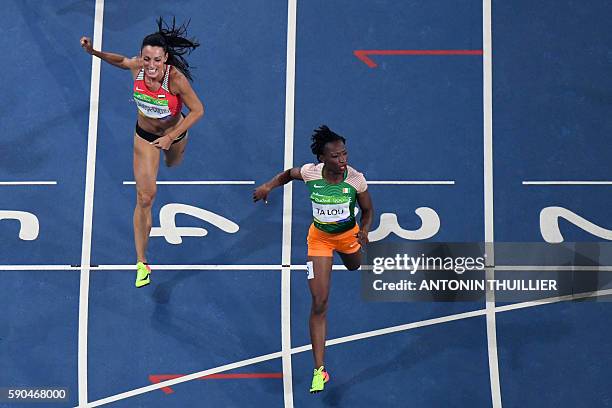 Ivory Coast's Marie-Josee Ta Lou crosses the finish line ahead of Bulgaria's Ivet Lalova-Collio as they compete in the Women's 200m Semifinal during...