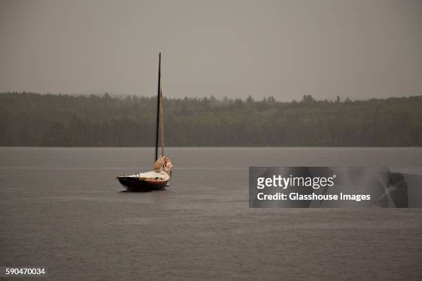 sailboat moored in lake during rain - anchored concept stock pictures, royalty-free photos & images