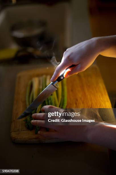 young adult woman chopping asparagus with knife - asparagus stock pictures, royalty-free photos & images